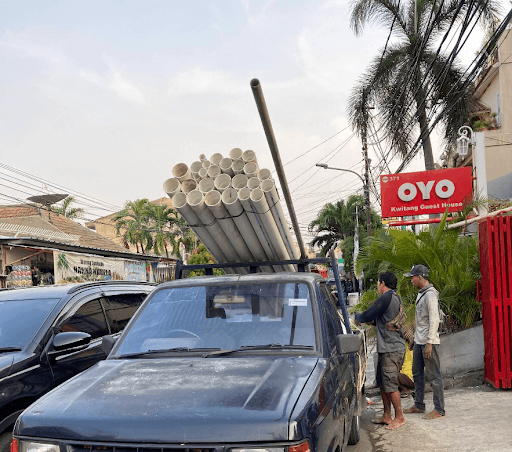 Armada pick-up memuat tumpukan pipa PVC tebal siap antar pesanan di depan Kwitang